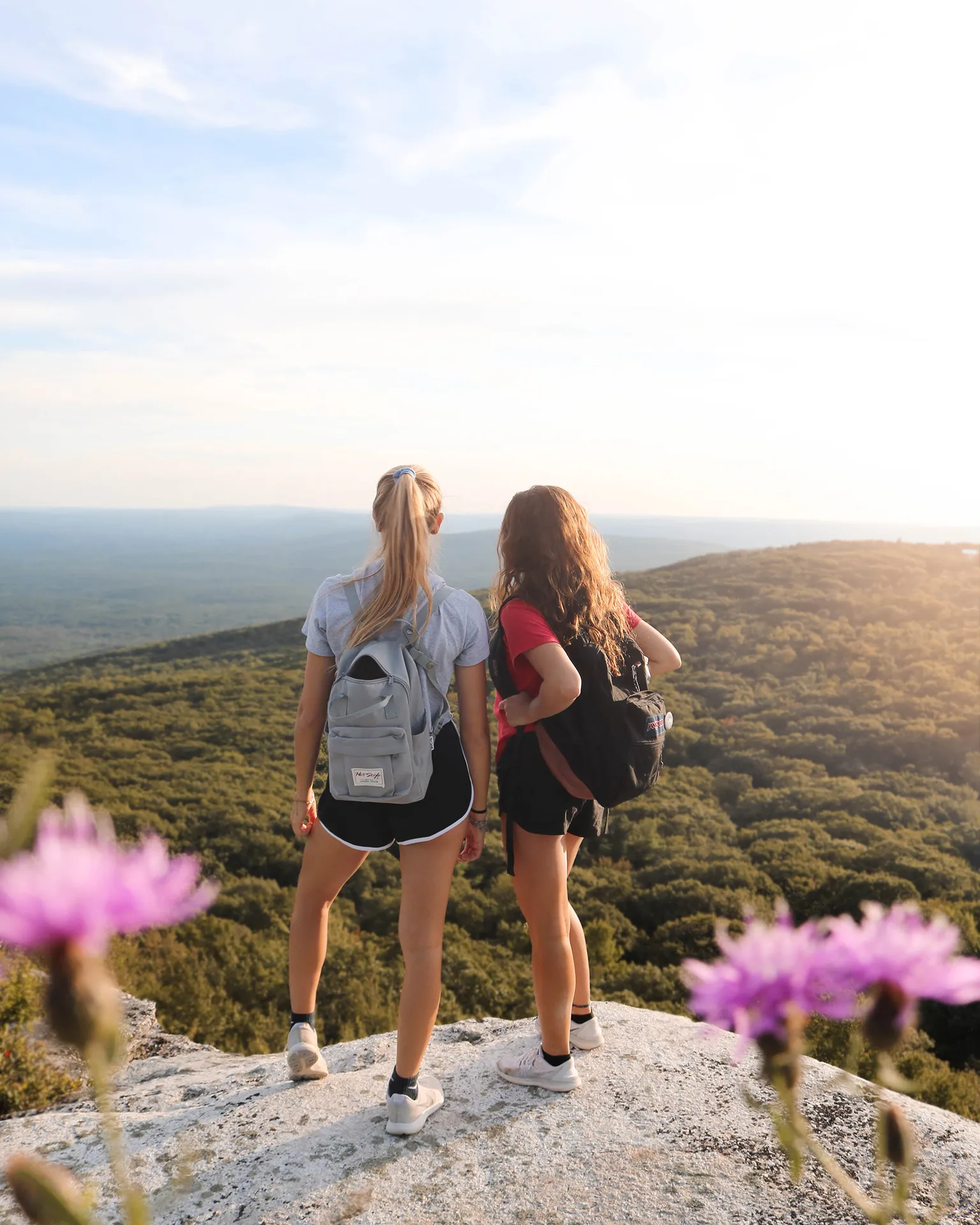 Deux jeunes femmes posent en haut d'une montagne